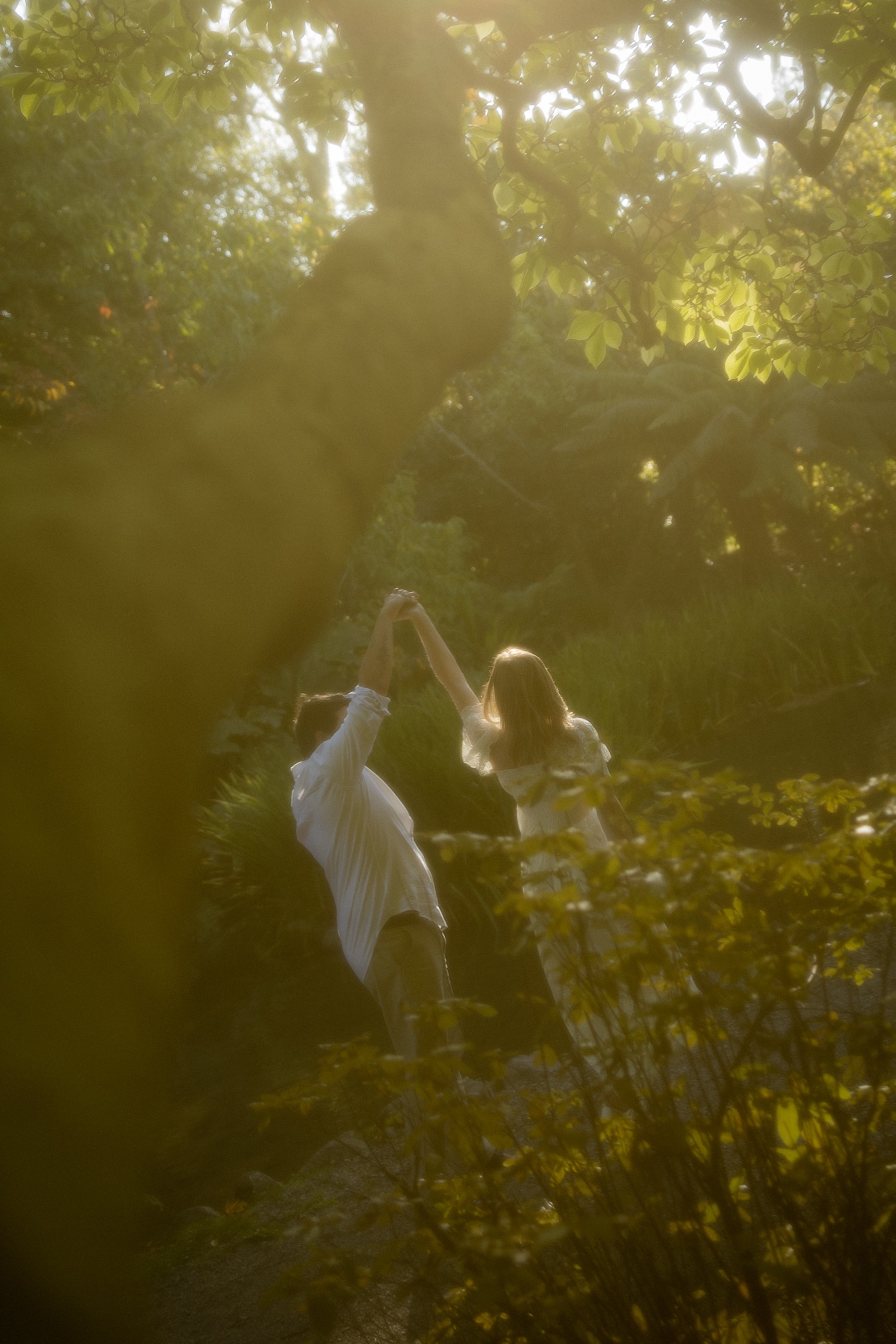 Lachlan and Renee dancing together under sunlit trees